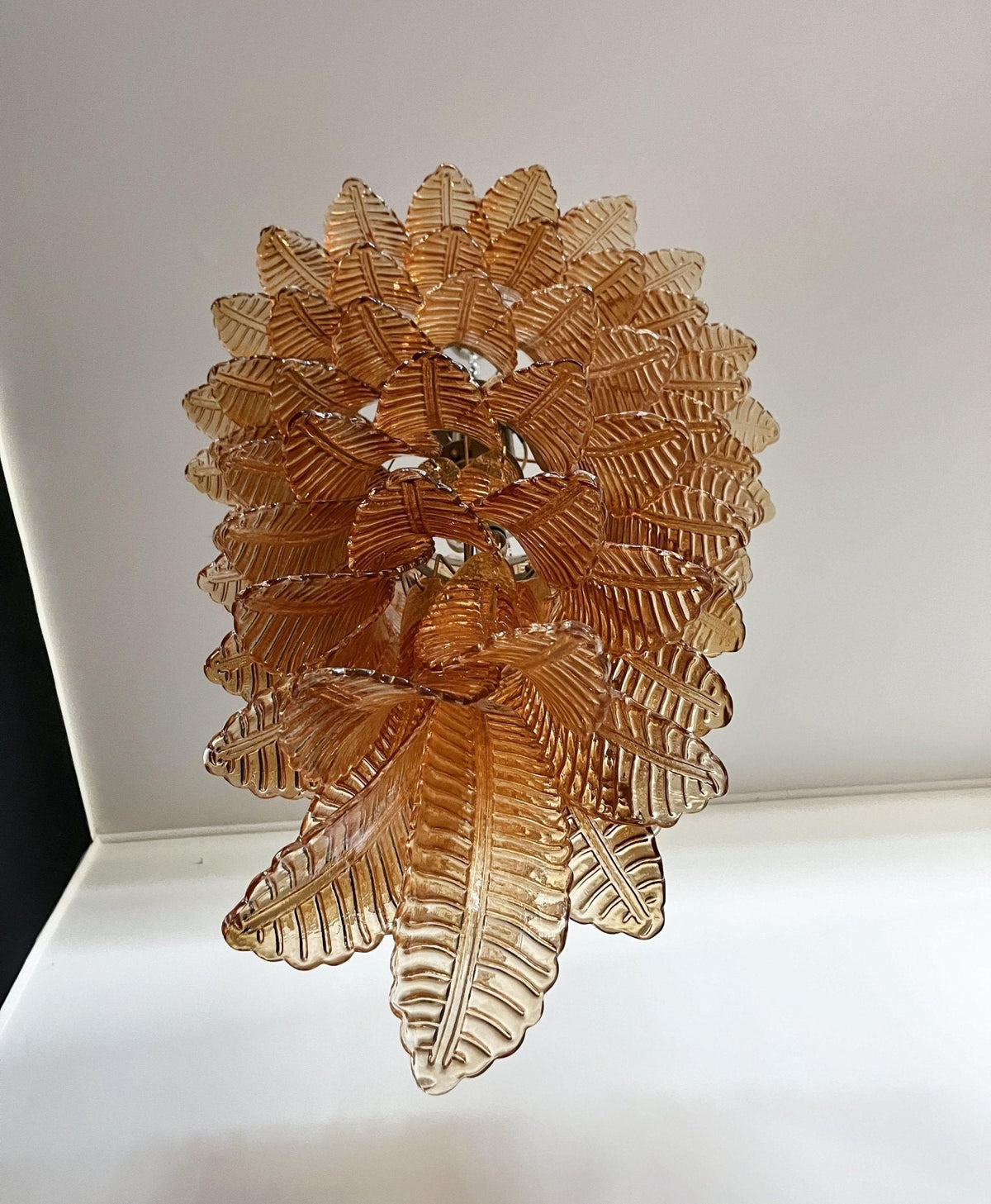 Celielle lysekrone med ravfarvede glasblade, lagdelt og markant kunstnerisk