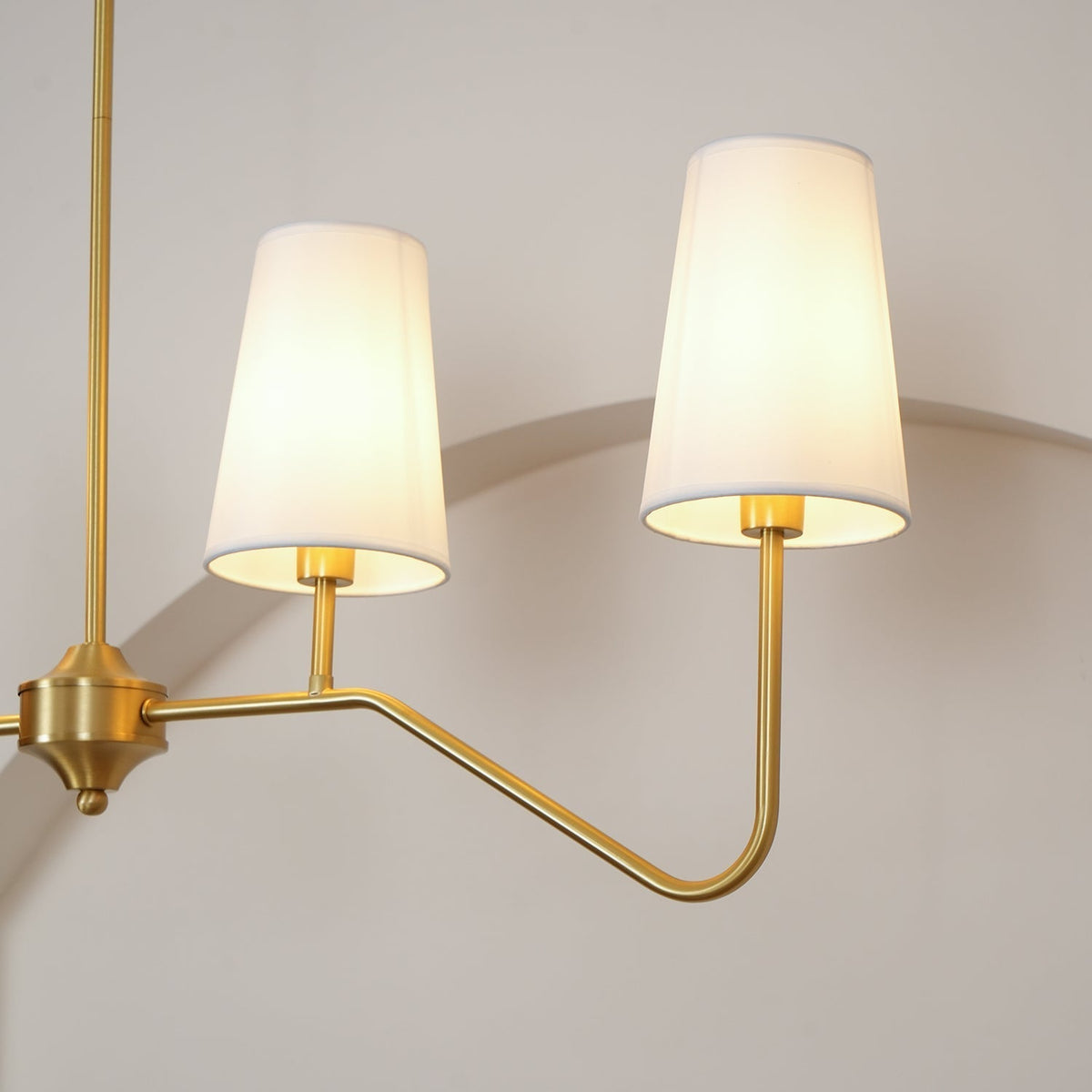 Oriinissa lysekrone i messing, buet, beige og lineær