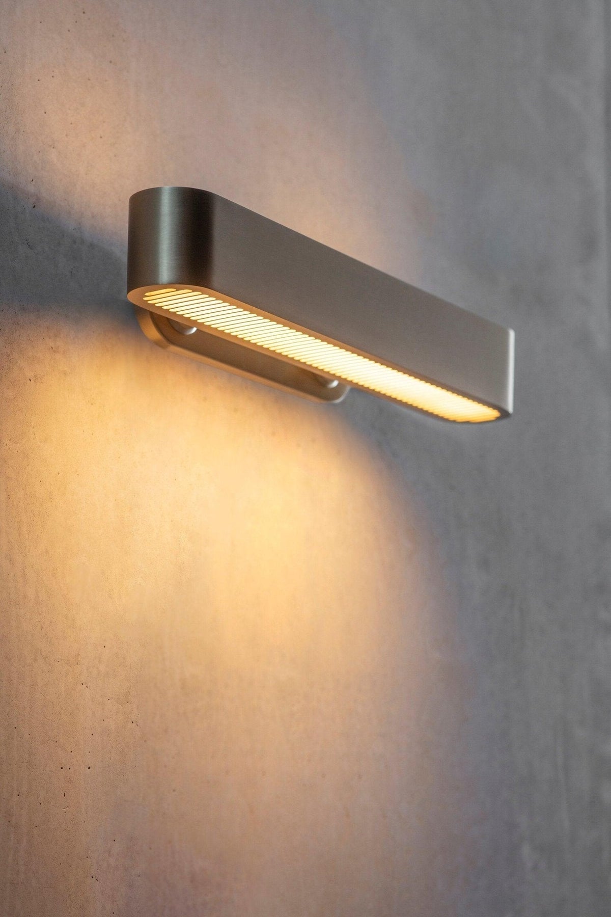 Oriararia vägglampa i mässing med slitsgaller