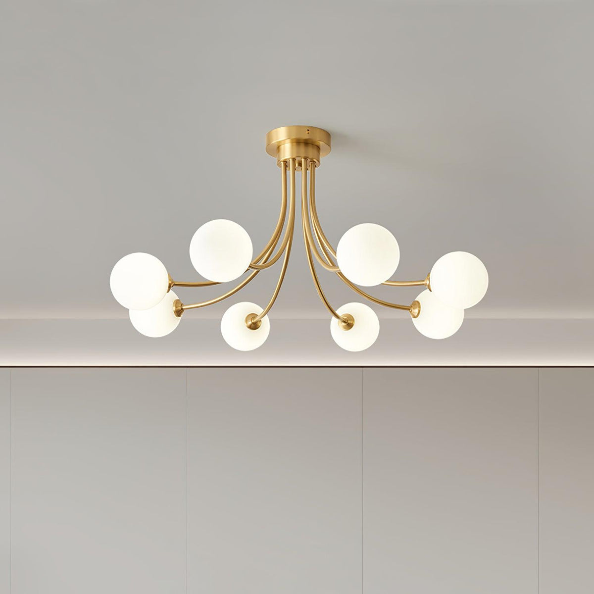 Loftslampe i messing med forgrenede arme og opale kugleskærme, moderne og elegant