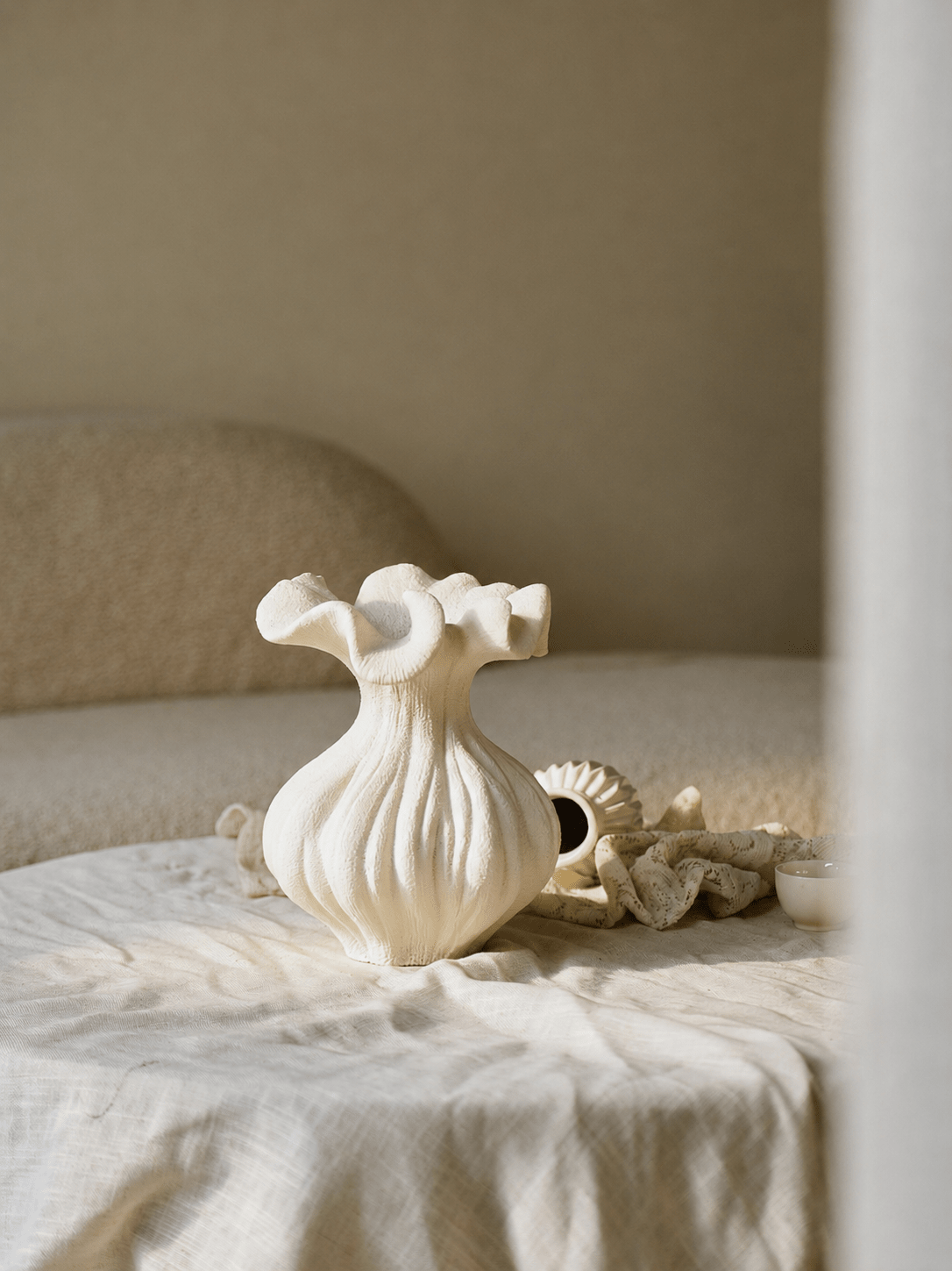 Skulpturel vase med sandtekstur i elfenbensfarve