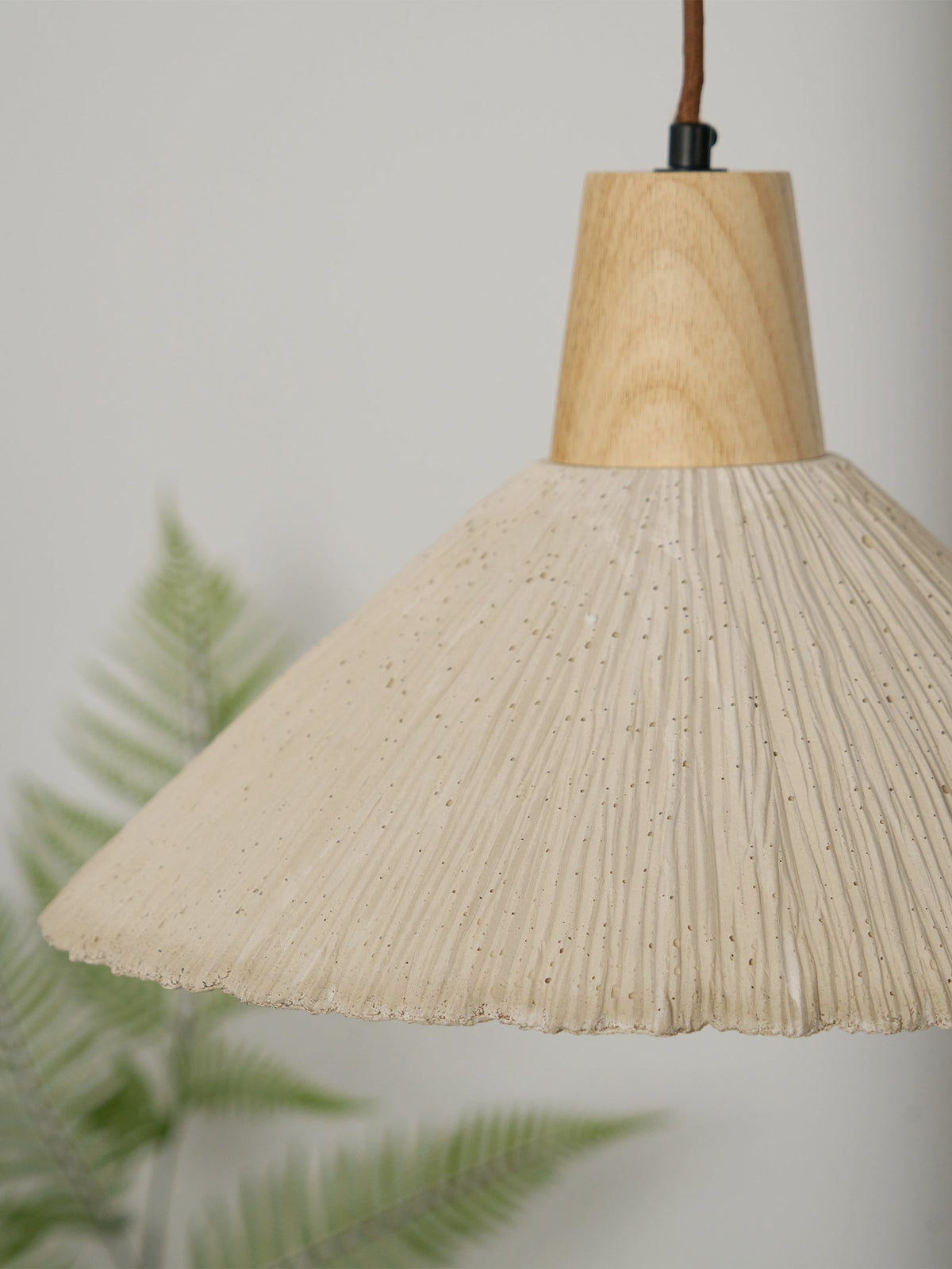 Pendel-lampe med trætophæng og tekstureret cementskærm i grå og naturfarver i japandi-stil