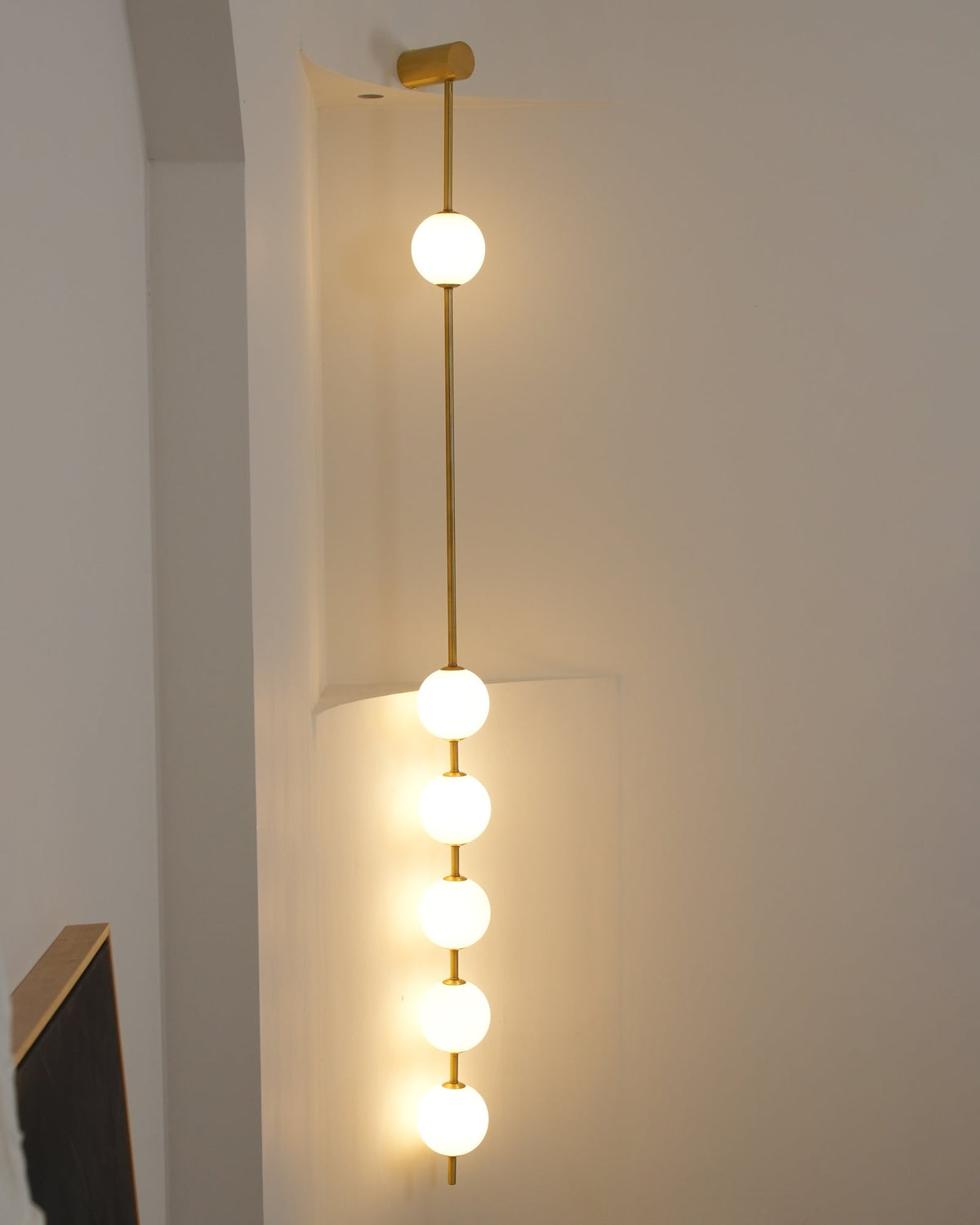 Luminária de parede Soloiella com bolas verticais em latão