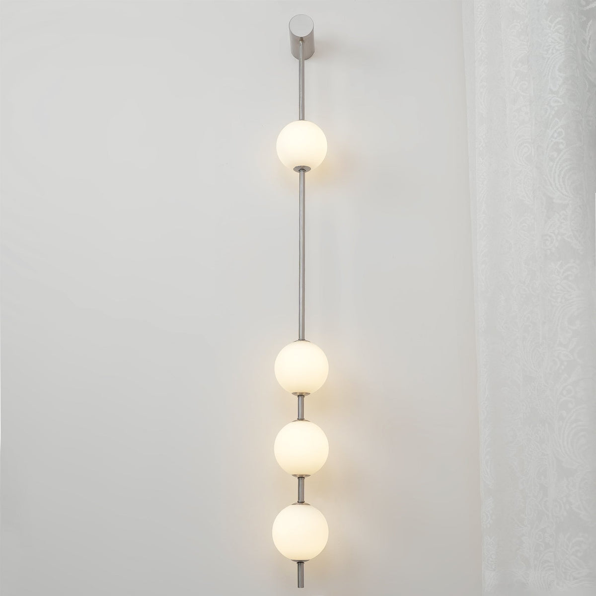 Luminária de parede Soloiella com bolas verticais em latão