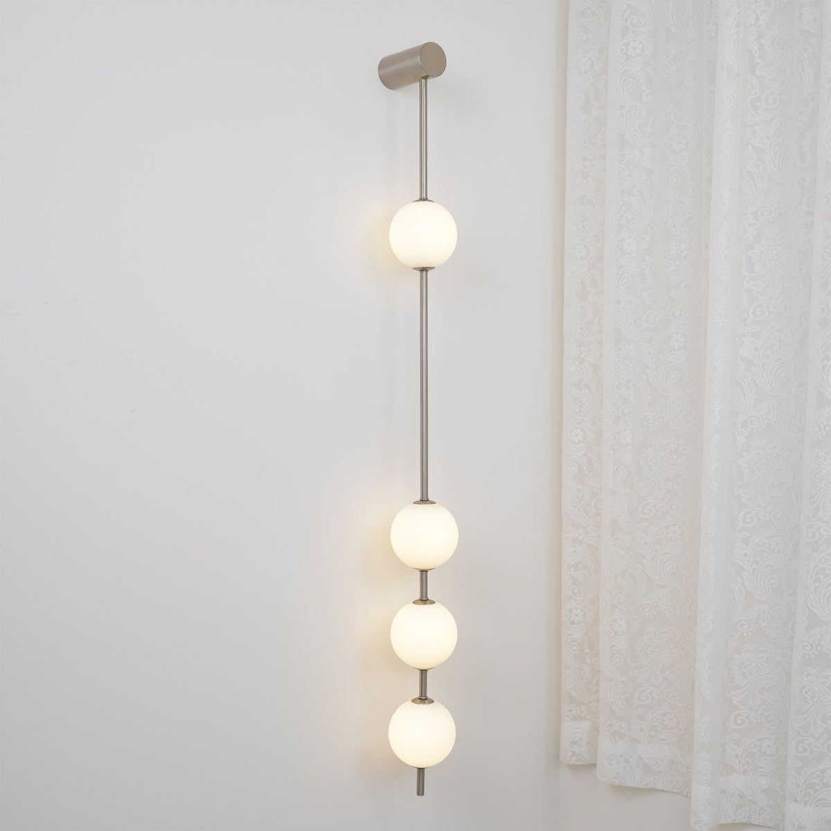 Luminária de parede Soloiella com bolas verticais em latão