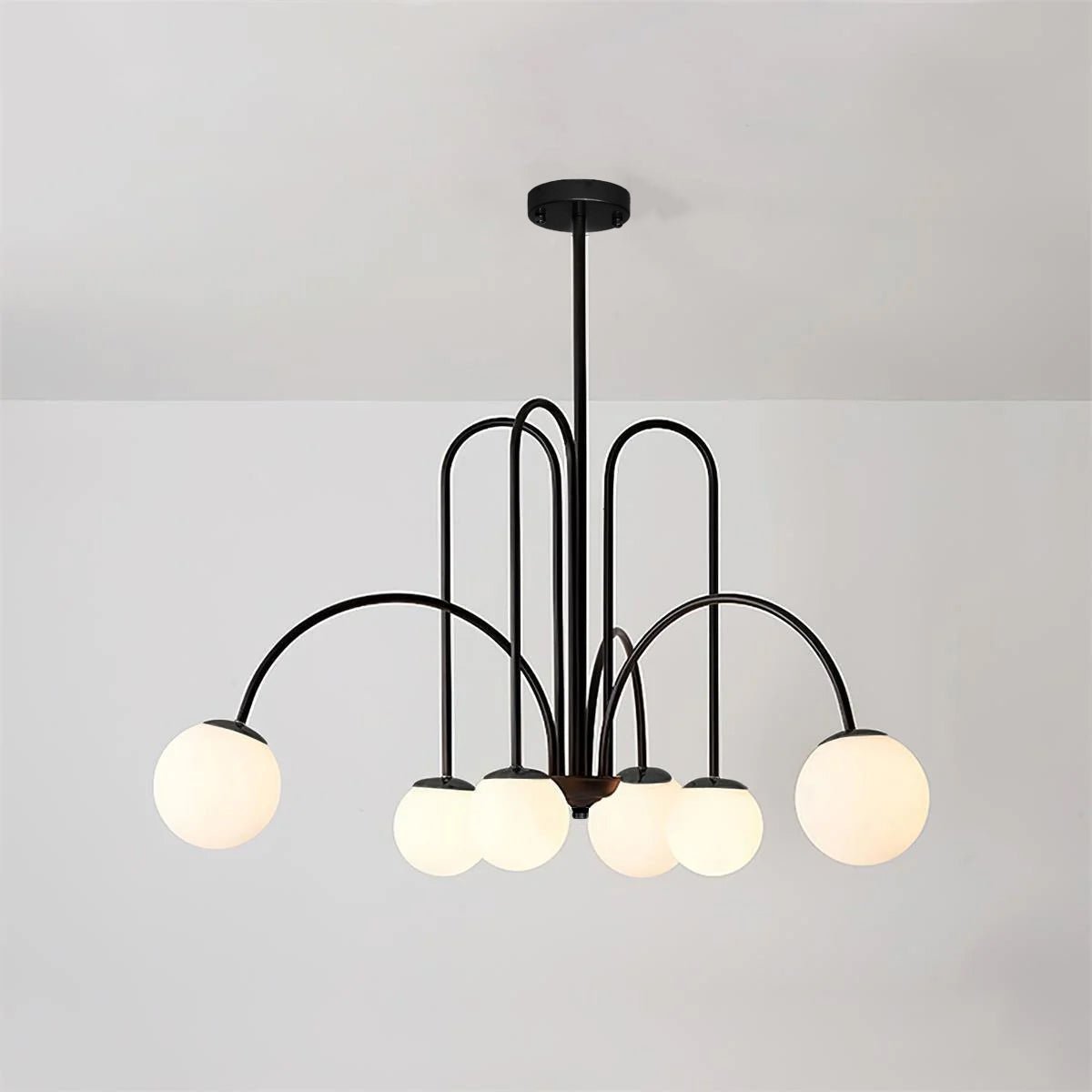 Sevi lysekrone i messing med buede arme og hvide glaskupler