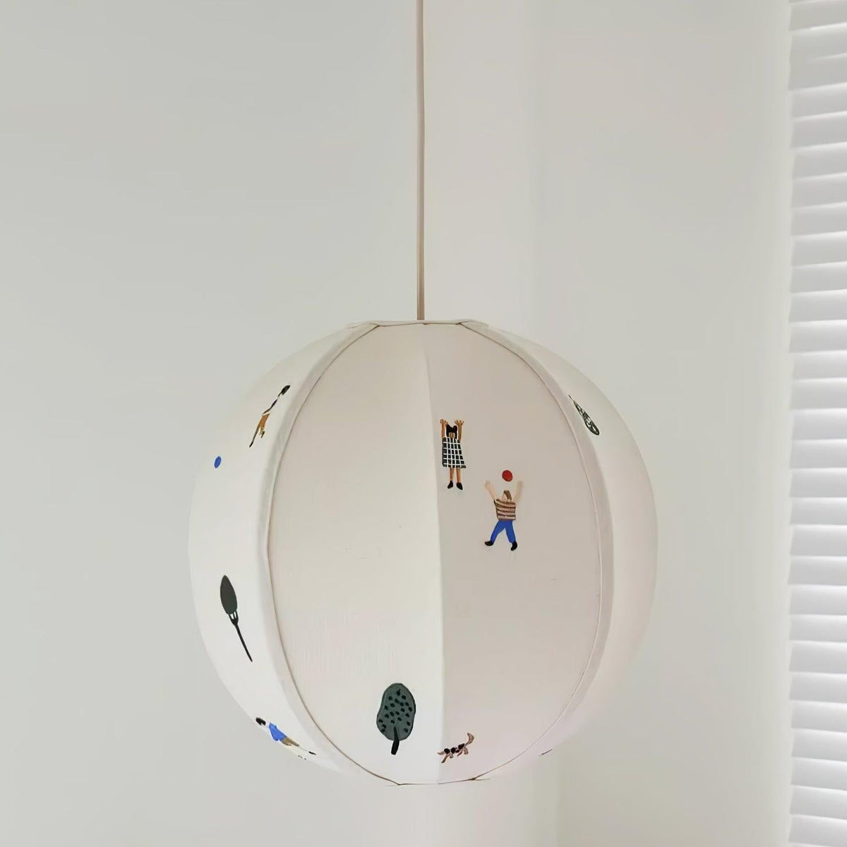 Elva pendellampa i papper med bollmotiv