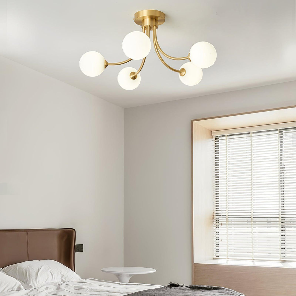 Loftslampe i messing med forgrenede arme og opale kugleskærme, moderne og elegant