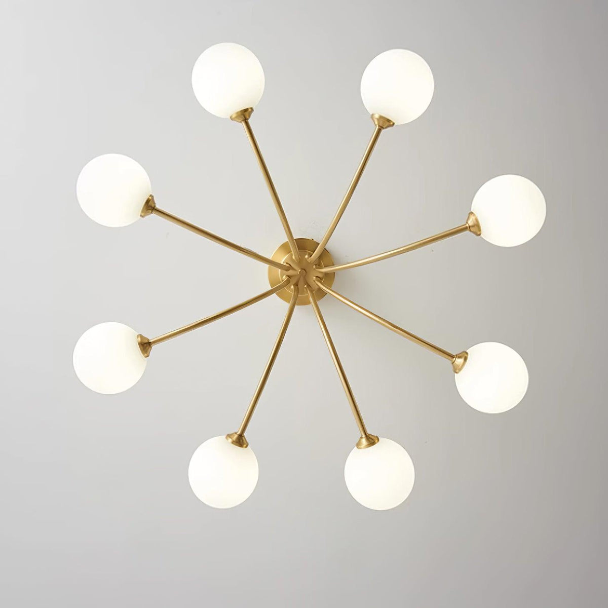 Loftslampe i messing med forgrenede arme og opale kugleskærme, moderne og elegant