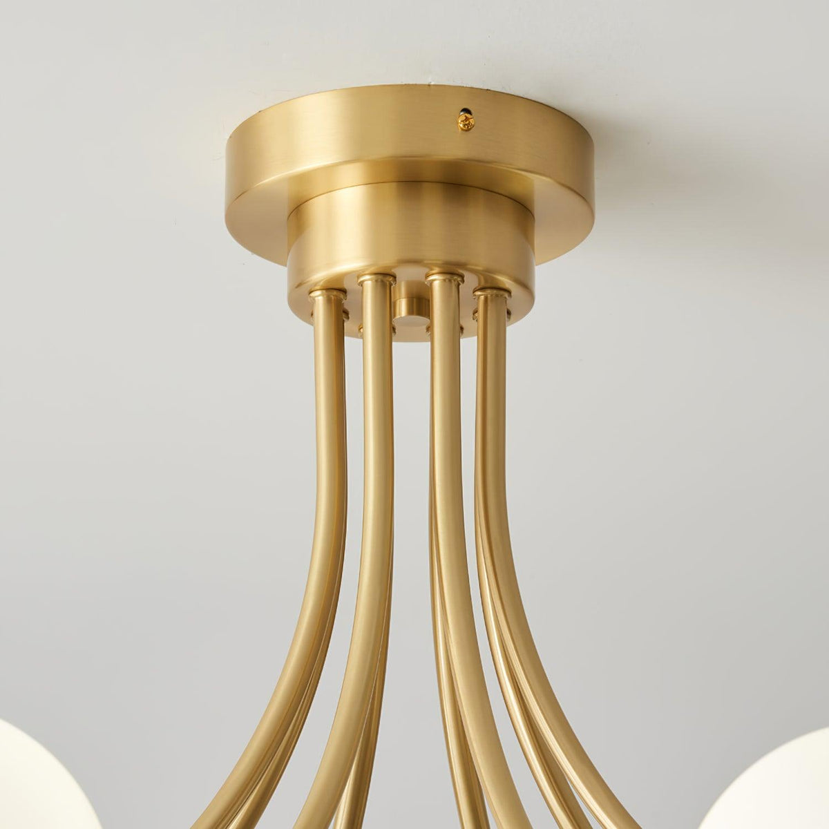 Loftslampe i messing med forgrenede arme og opale kugleskærme, moderne og elegant