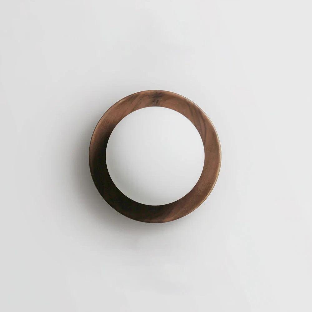 Candeeiro de parede com corpo metálico e aro de madeira, de estilo minimalista