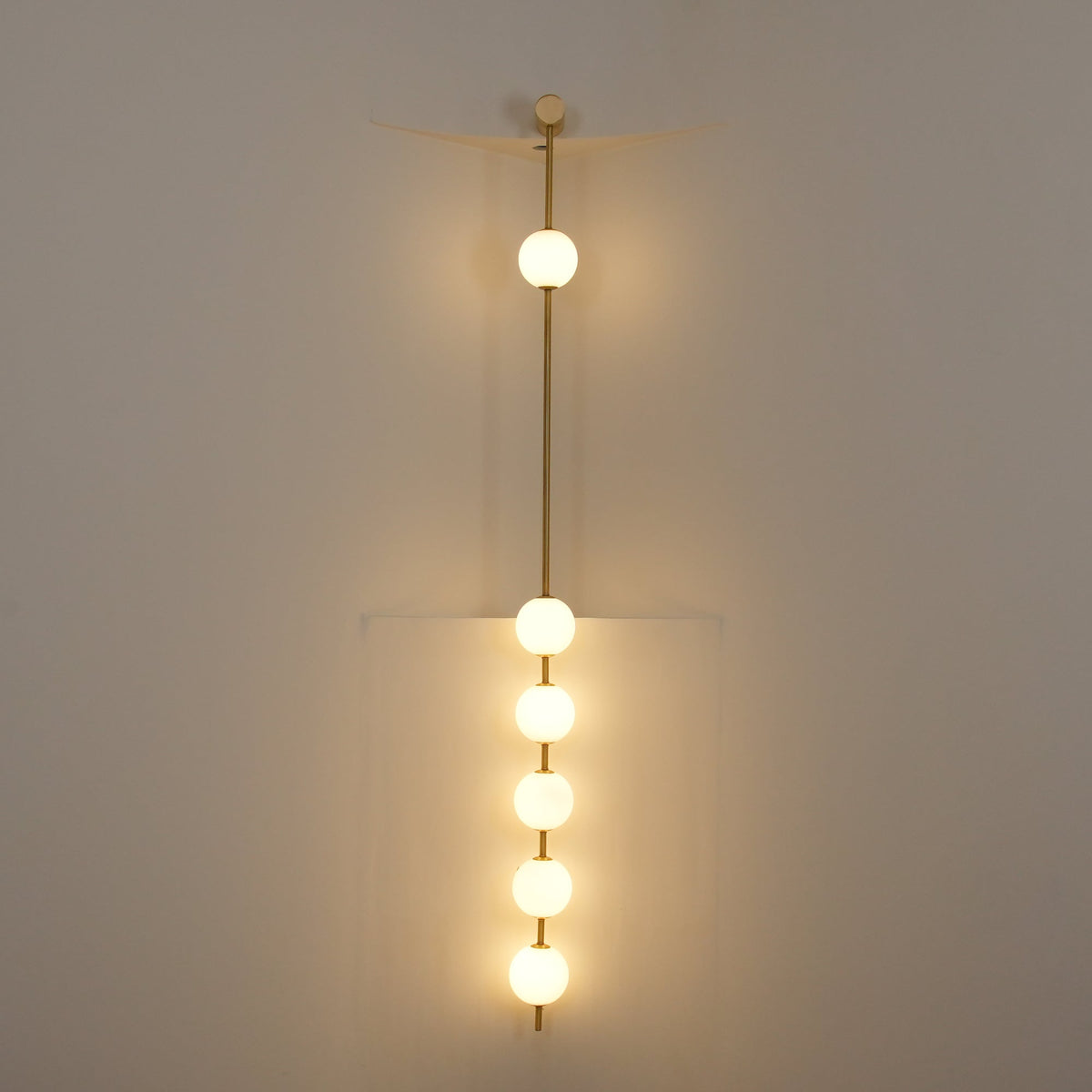 Luminária de parede Soloiella com bolas verticais em latão