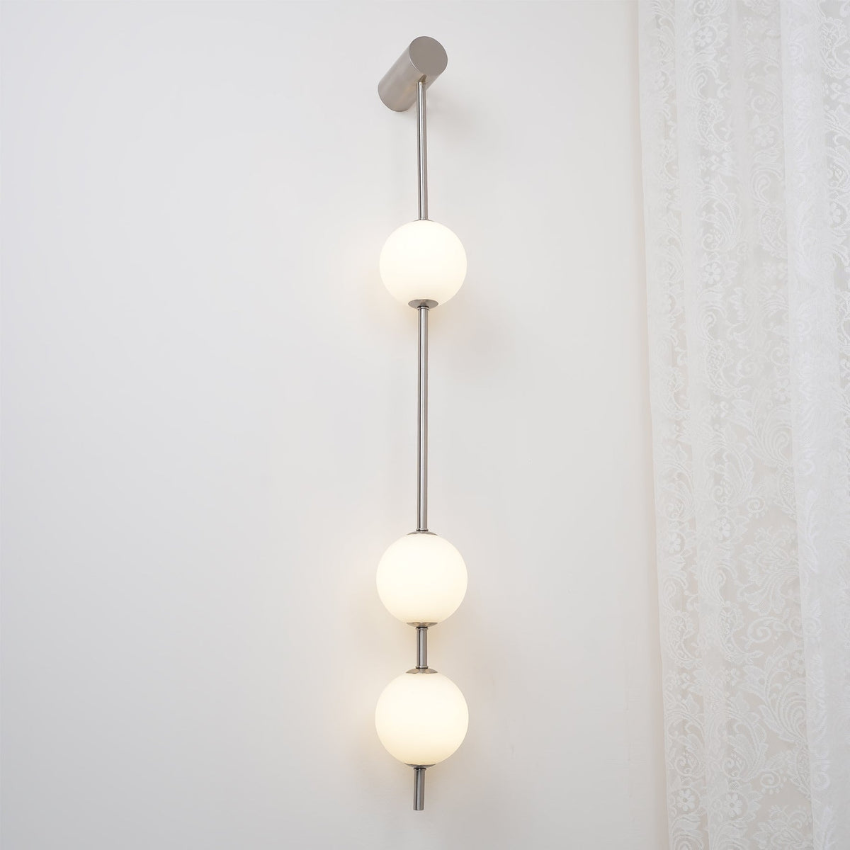 Luminária de parede Soloiella com bolas verticais em latão