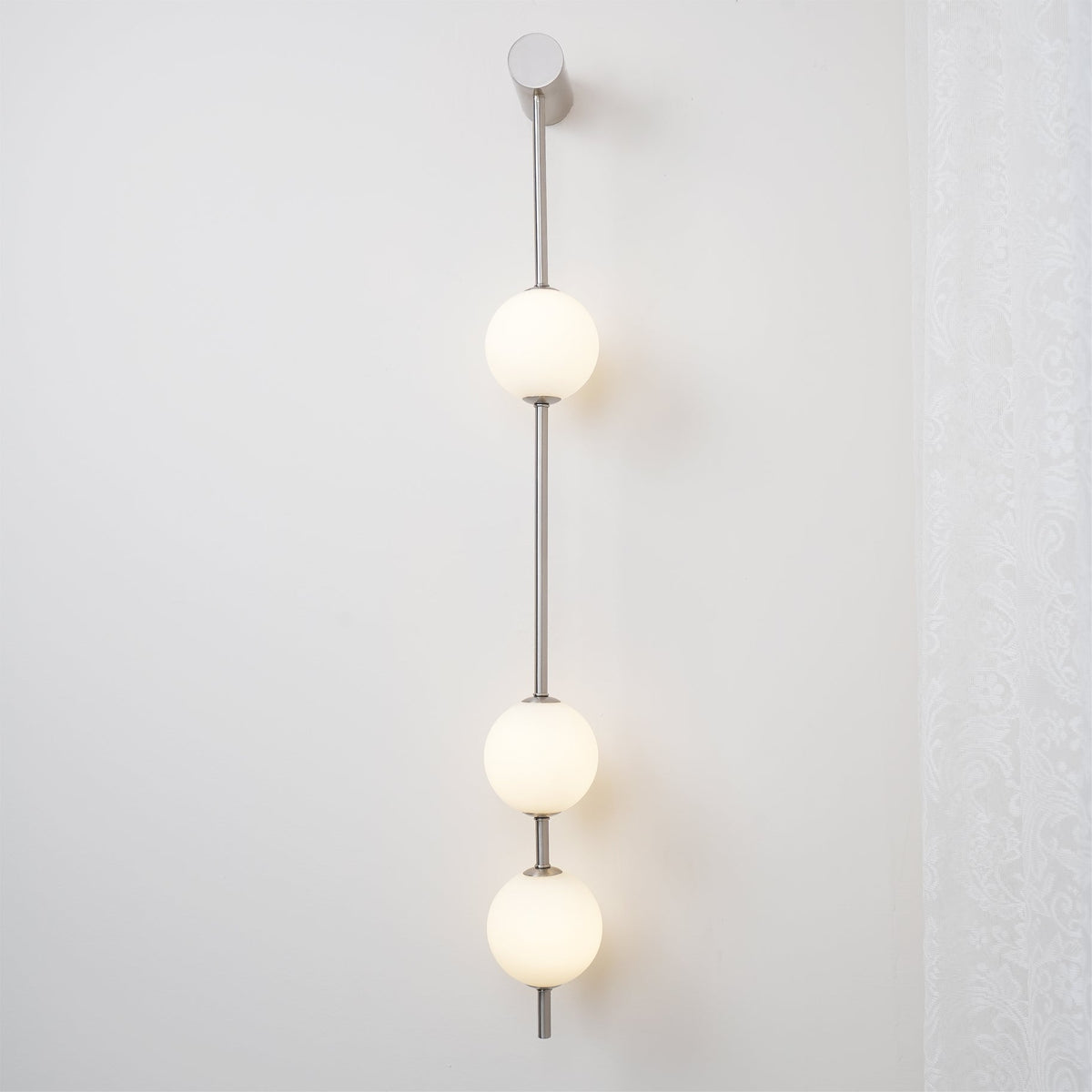Luminária de parede Soloiella com bolas verticais em latão